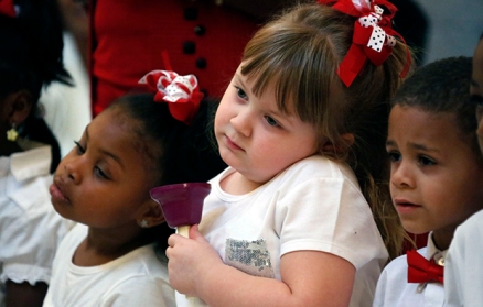 Angel Nevins, center, and her friend and classmate Jade Smith, left, wait for their signal to ring their hand bells as children from the Anderson Grove Head Start program in Caledonia, Mississippi, ring their hand bells to accompany several patriotic songs, Tuesday, February 26, 2013, at the Capitol in Jackson, Mississippi.